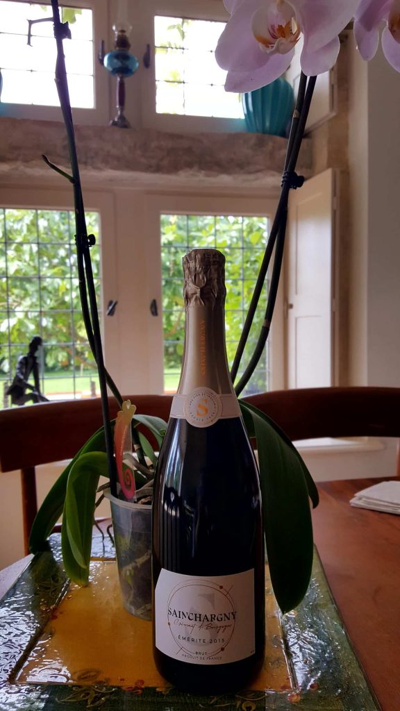Bouteille de Crémant de la Cave de Lugny disposé sur table à La Cadole de Chardonnay