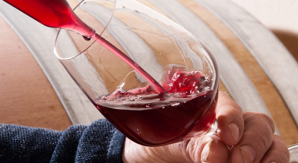 Main de Jean-Yves Blanchard qui sert un verre de rouge